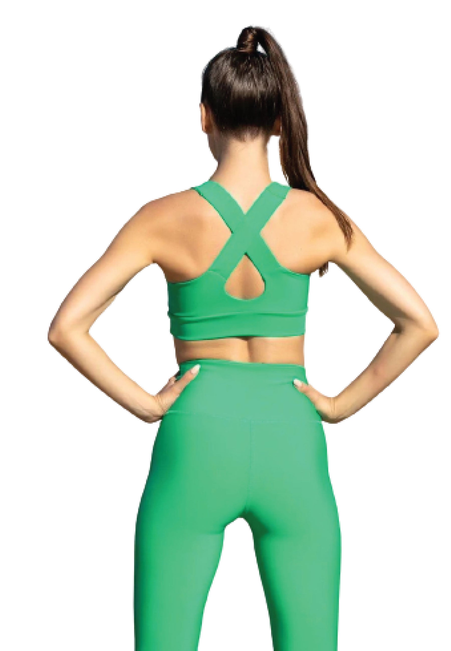 Frau in Lisminas 185 Single Crossed Sport Bra in Grün, Pferdeschwanz, Hände auf den Hüften, von hinten gesehen.